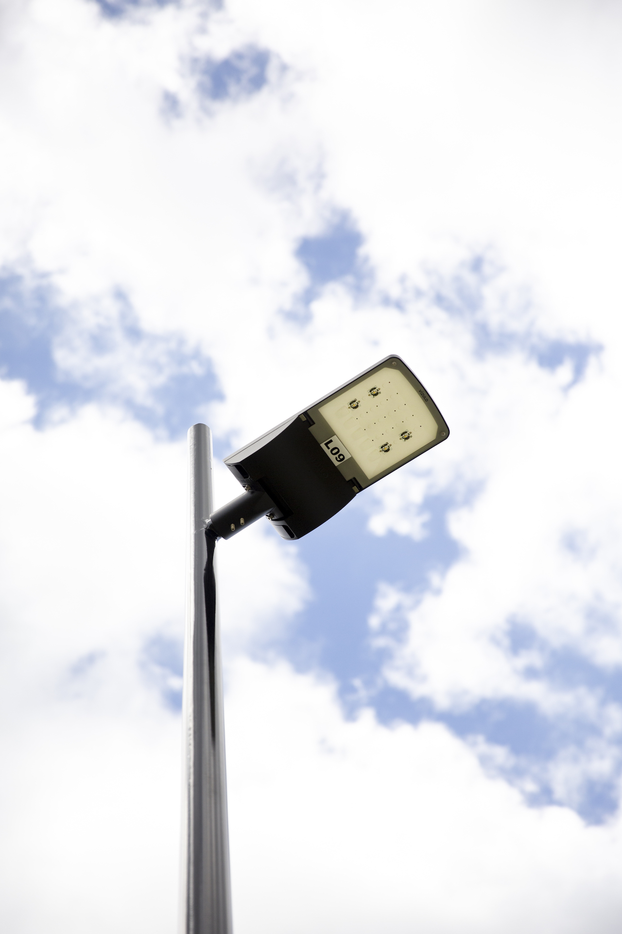 Auranga street light called Cromwell by ibex lighting with a cloudy sky in the background.