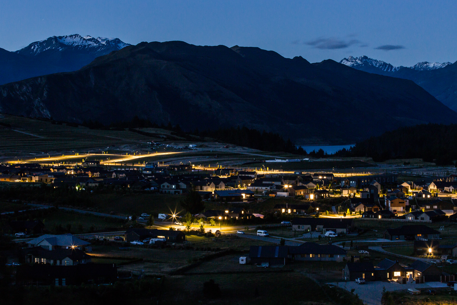 Northlake neighbourhood overview at night illuminated by ibex lighting solutions with magnificent mountains in the background.