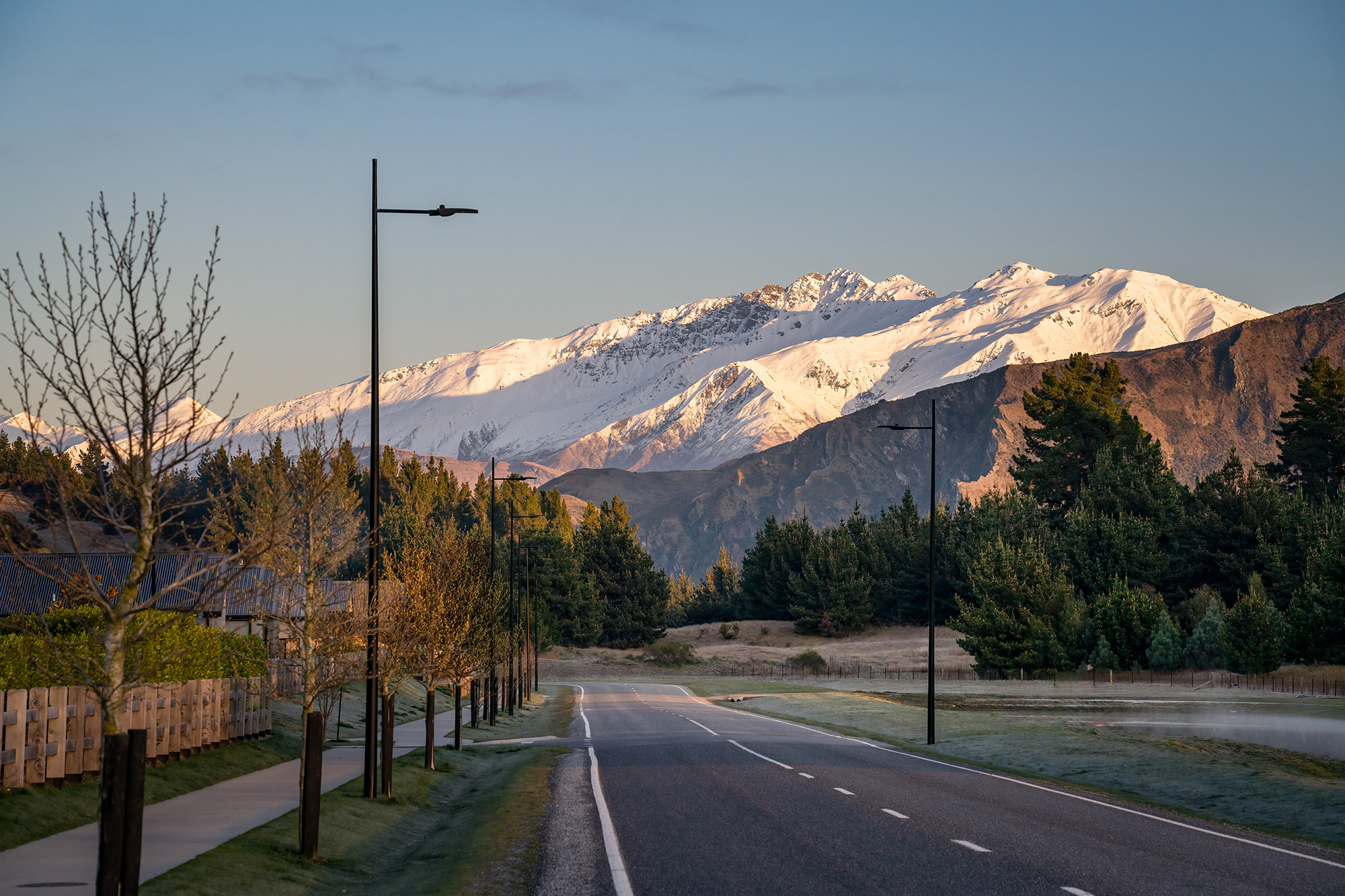 Northlake neighbourhood road illuminated by ibex lighting solutions with magnificent mountain in the background.